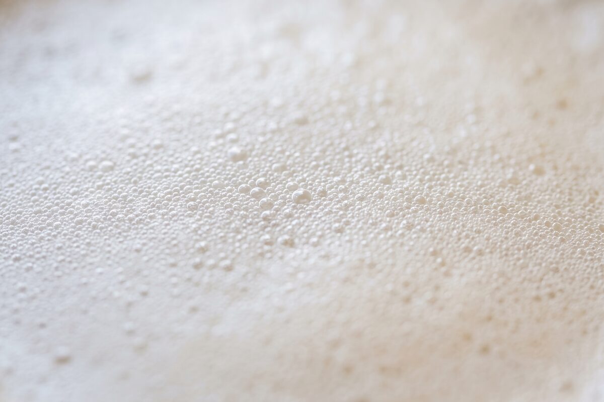 Extreme close-up of dense, even oat milk microfoam